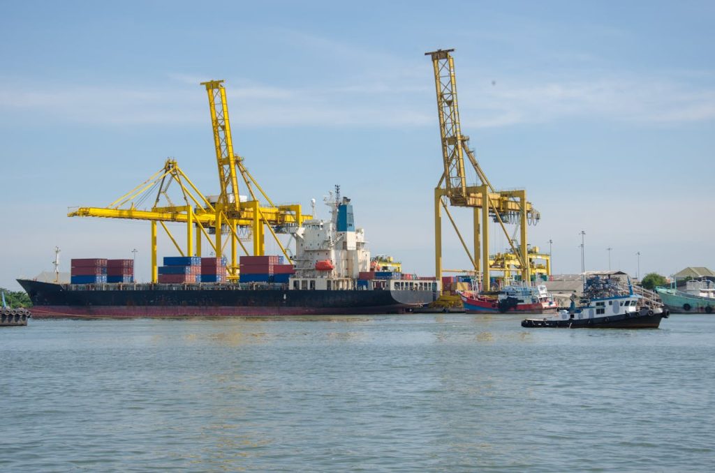 pexels photo 1211787 A cargo ship docked at an industrial port with cranes and containers at a bustling harbor.