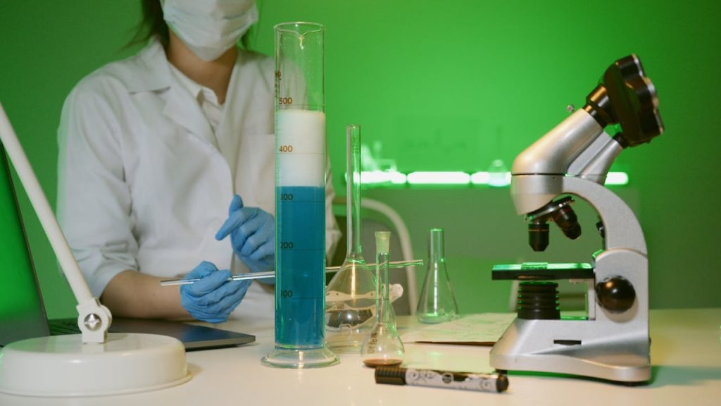 pexels photo 8533145 Female scientist in lab coat conducting experiment with blue liquid in laboratory setting.